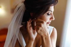morning of bride beautiful smiling brunette bride in white dress with wedding bouquet in her hands 