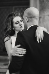Stylish wedding couple gently hugging and smiling