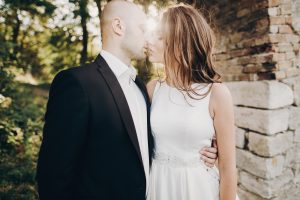 Stylish wedding couple gently hugging and walking