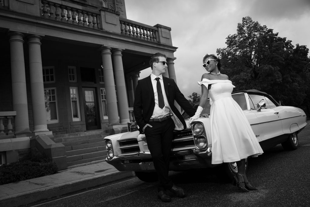 Elopement photography in Edmonton capturing a stylish couple by a classic car. Perfect for intimate.